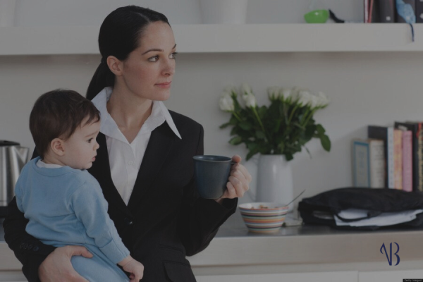 L'immagine raffigura una mamma sul posto di lavoro con in braccio il suo bambino. Vuole mettere in evidenza le lavoratrici madri